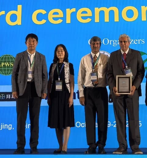 High-resolution image of four professionals receiving an award at the Weed Science Society of America conference, emphasizing leadership in weed management and sustainable agriculture.